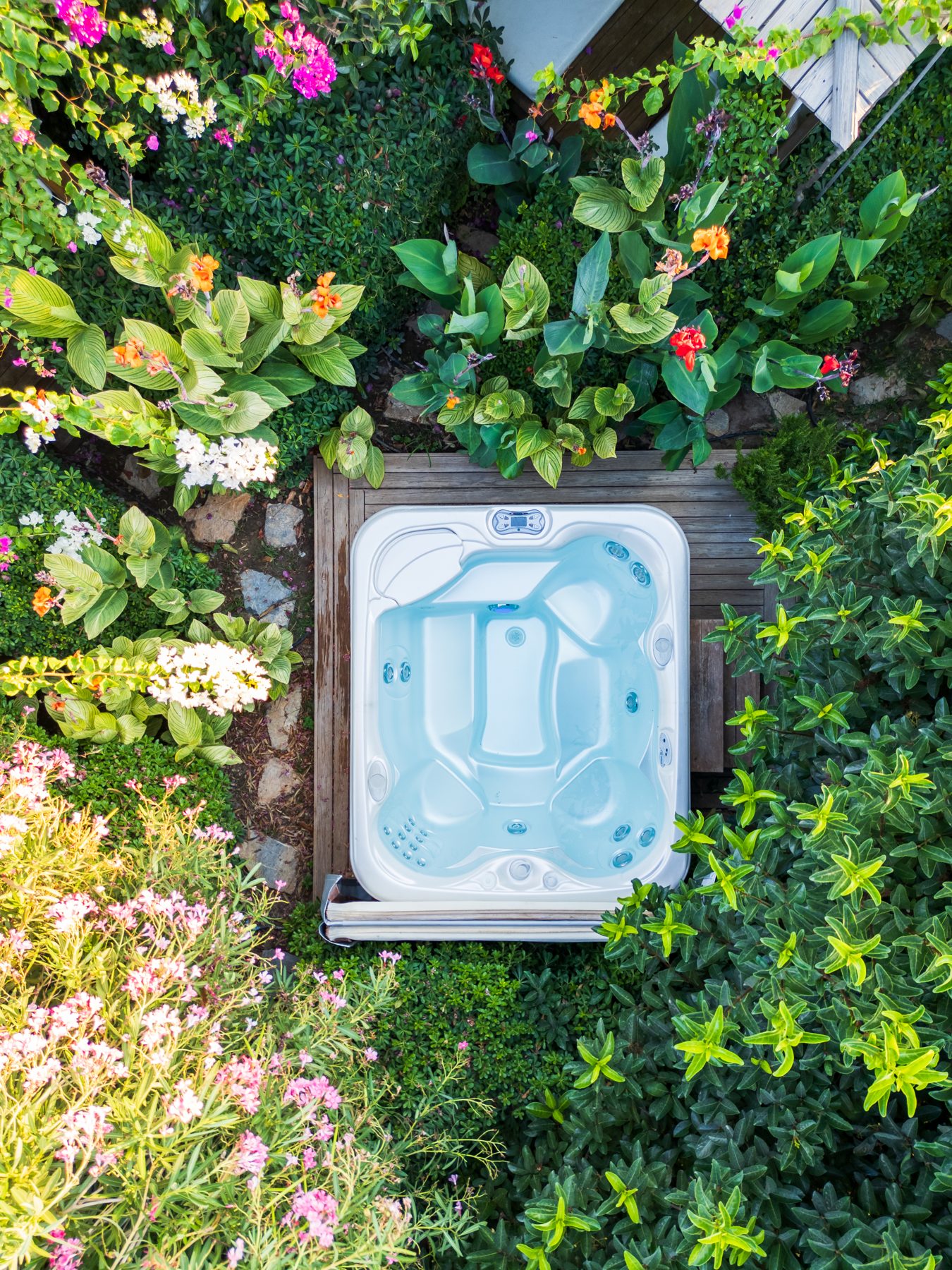 Hot tub framed by garden flowers