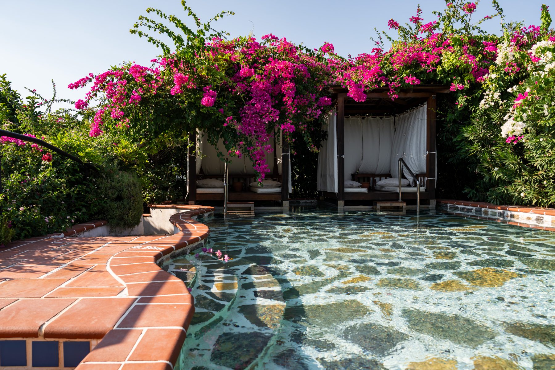 Cabana beds beside the mosaic pool